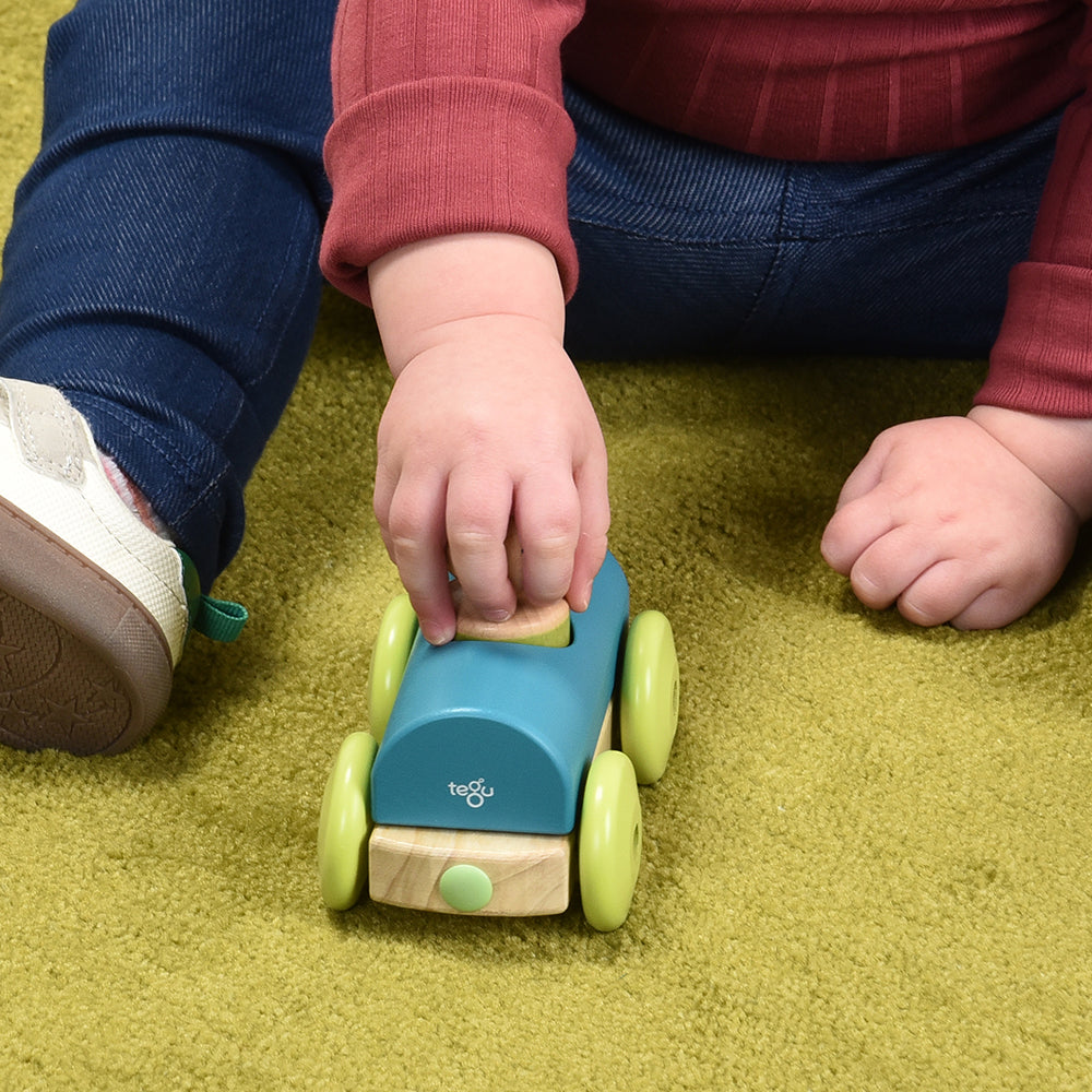 Close-up of Toddler Interacting with Tegu Teal Magnetic Racer