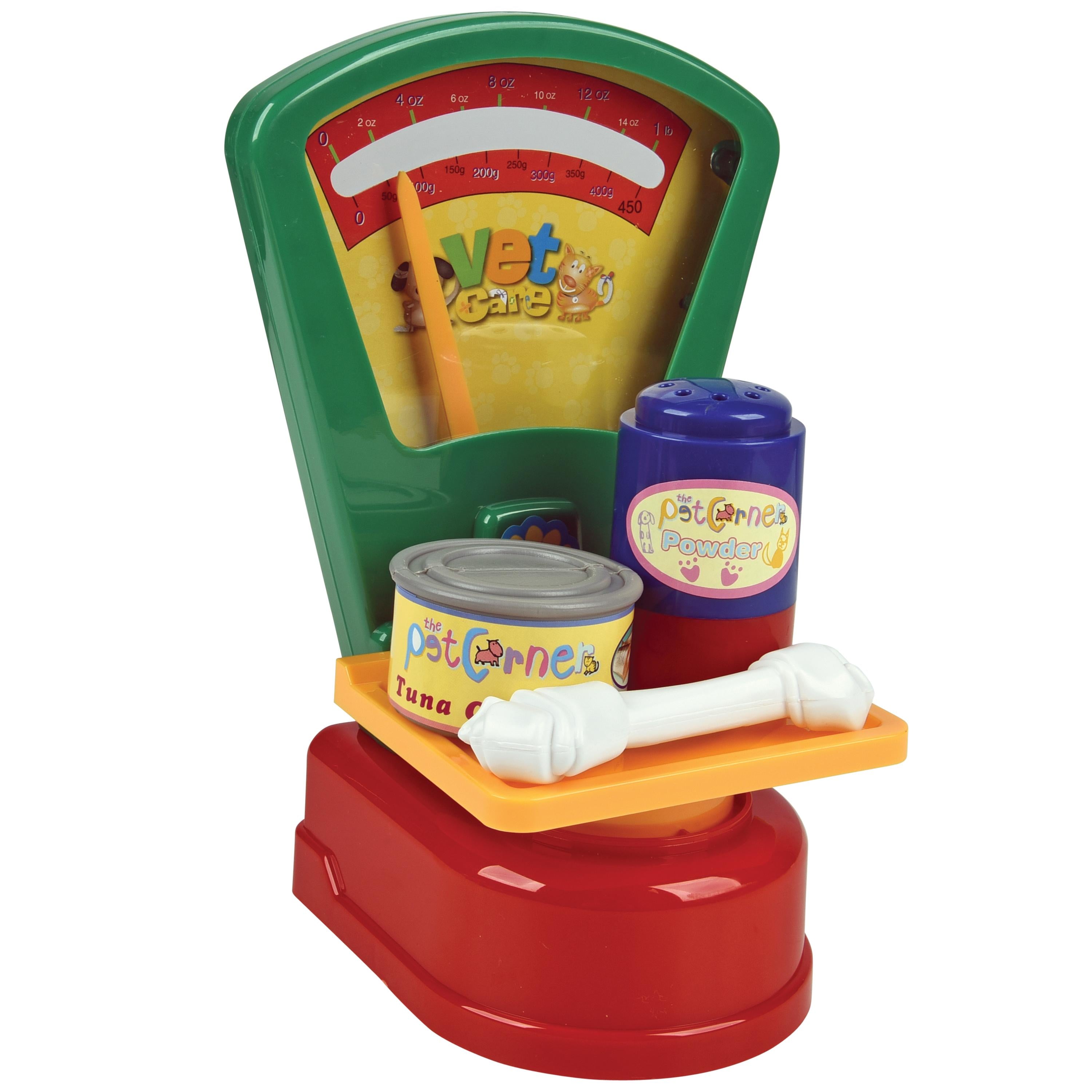 Toy pet scale with food containers and a bone on a white background