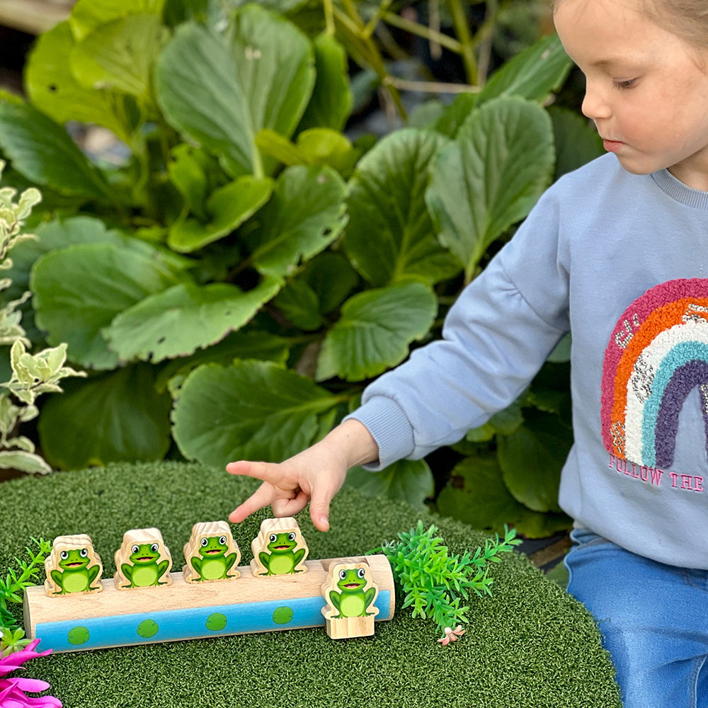 Child Engaging with Frogs On A Log Wooden Toy