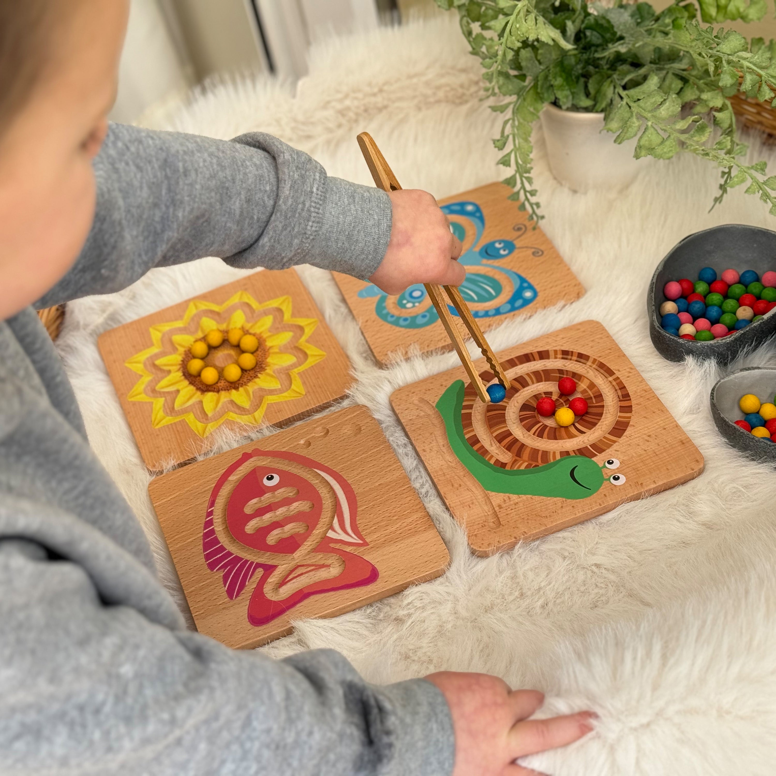 Child playing with wooden toys on a soft surface