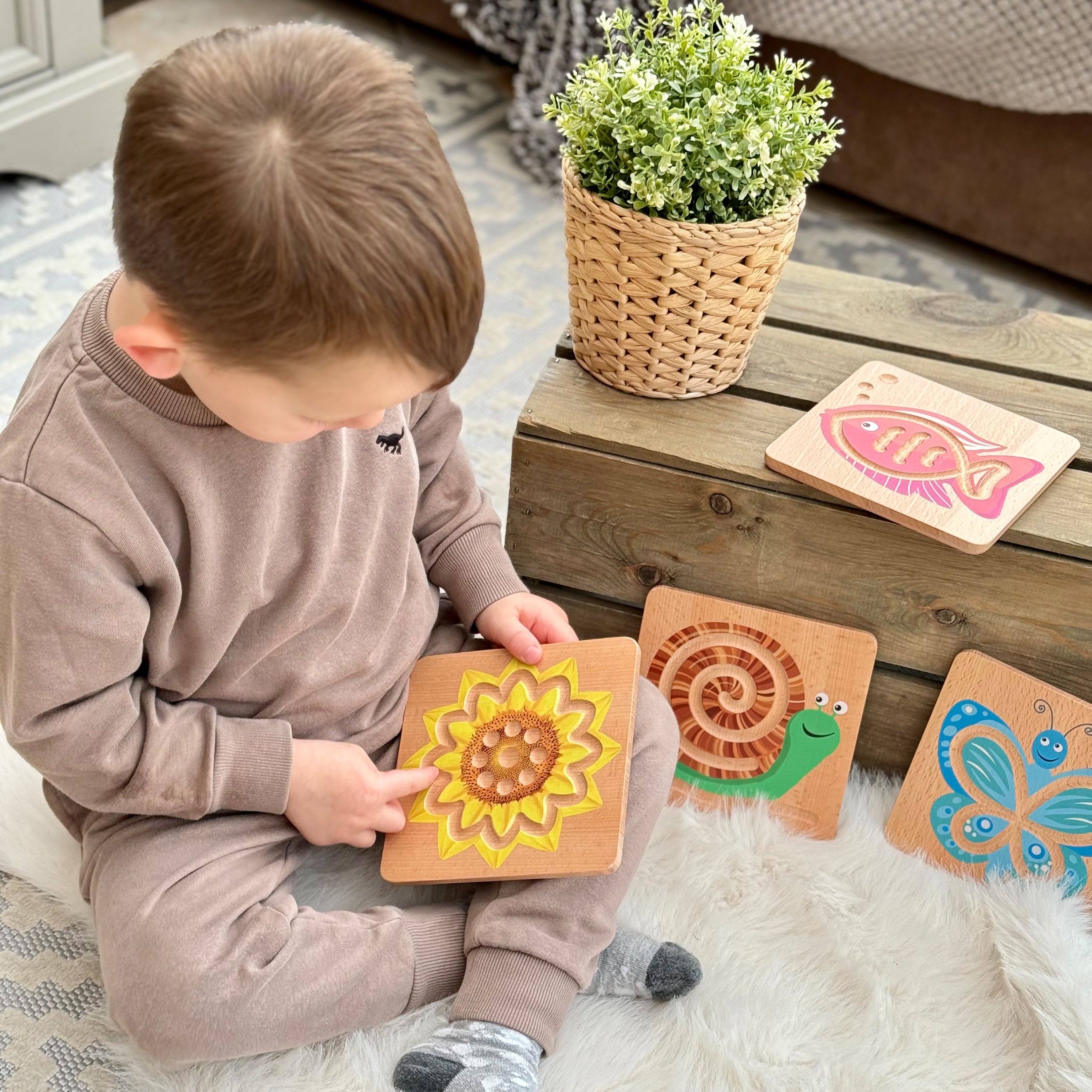 Child playing with wooden educational toys on a soft surface
