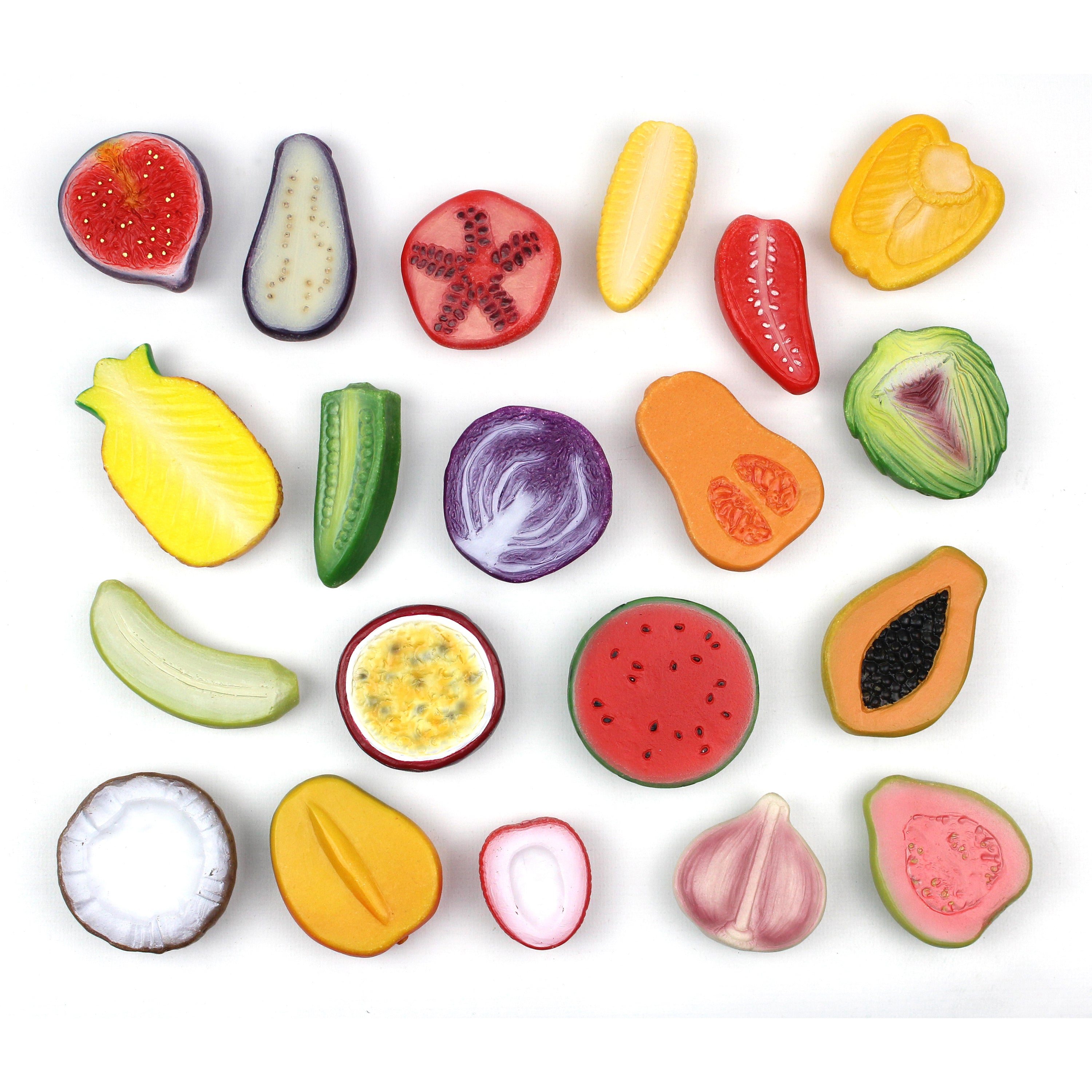 Assorted colorful fruit and vegetable slices on a white background