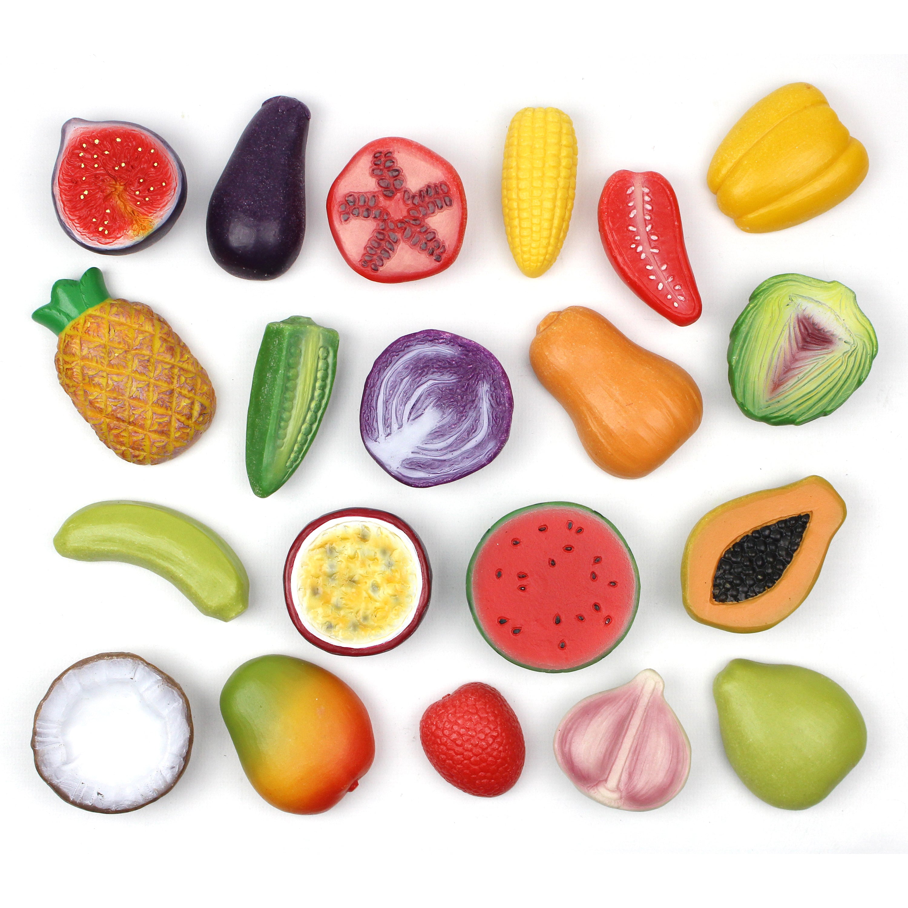 Colorful replicas of fruits and vegetables on a white background