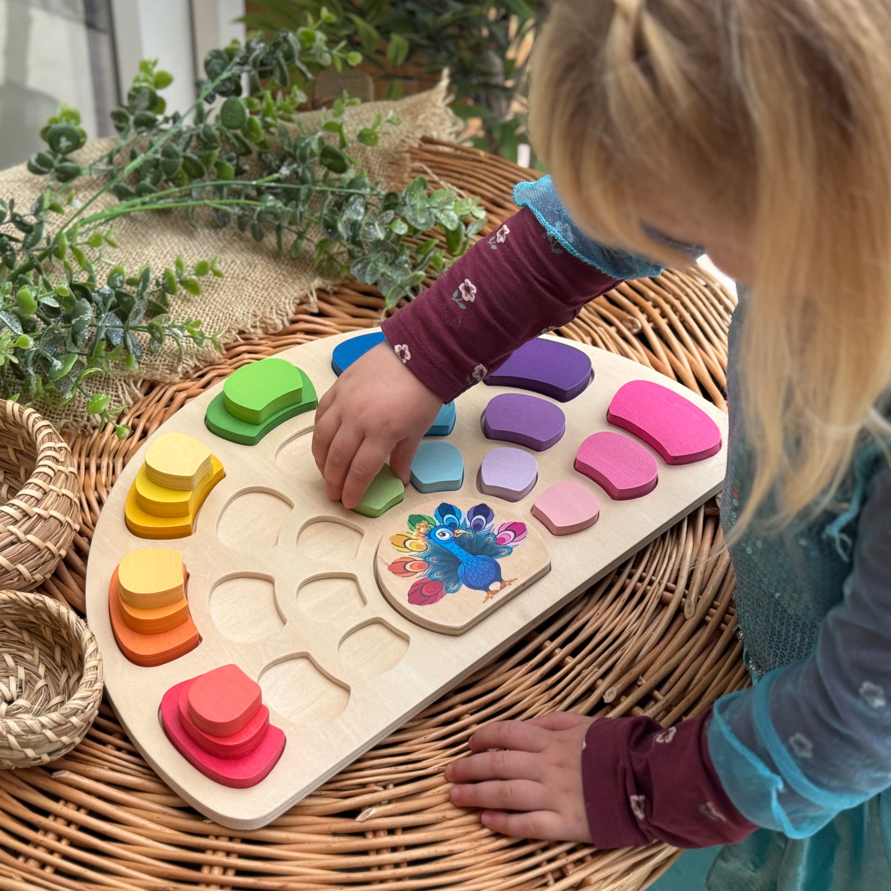 Child playing with a colorful wooden shape sorting toy on a wicker surface.