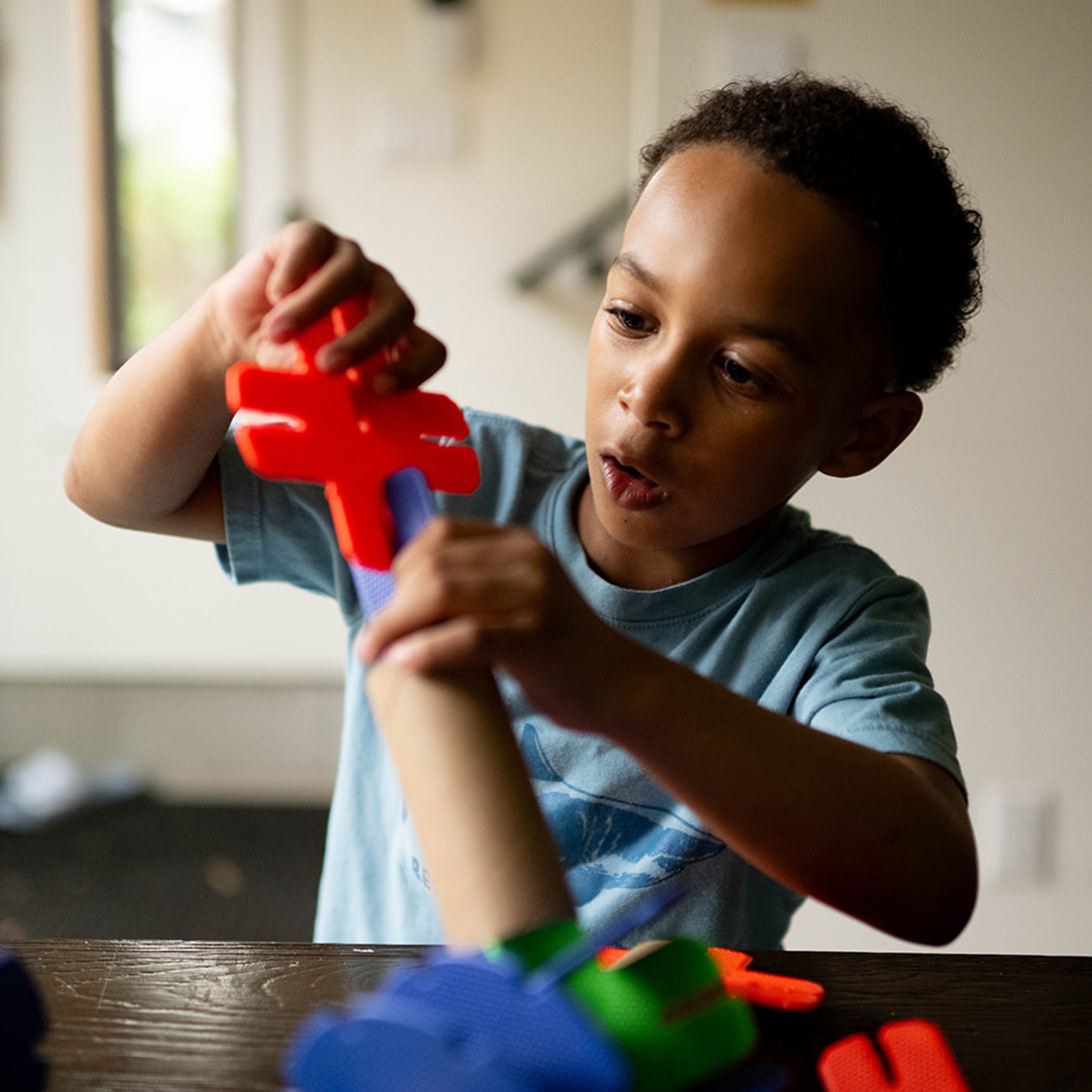 Child playing with colorful toys at a table